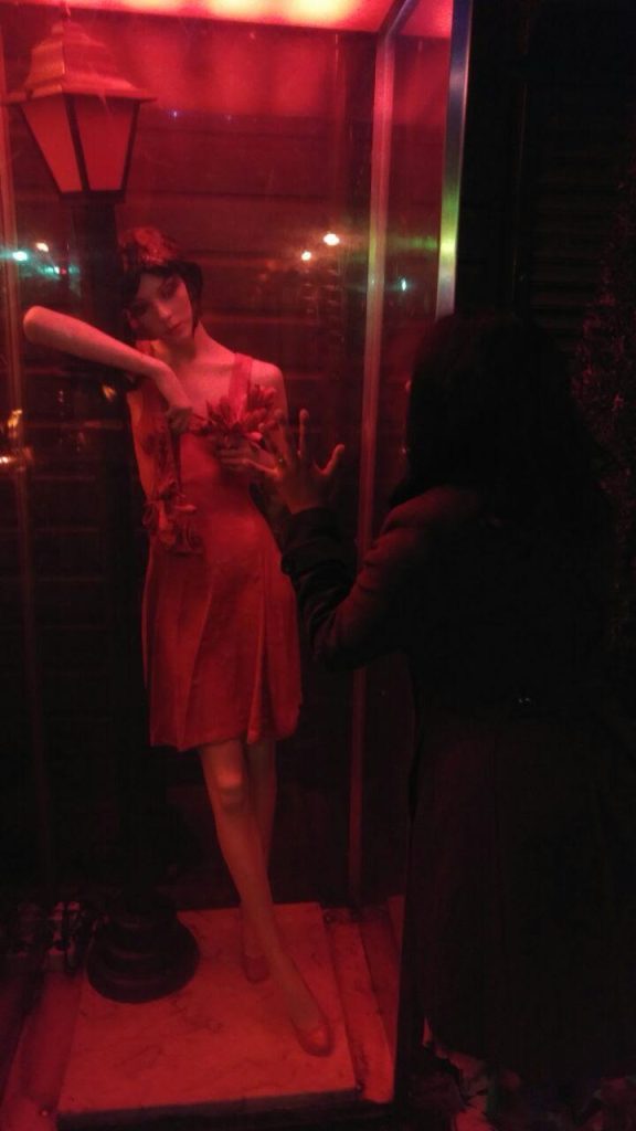 Photo of a statue representing a prostitute at the Red-Light District, in Amsterdam, the Netherlands. Foto de uma estátua representando uma prostituta no Distrito da Luz Vermelha, em Amsterdã, na Holanda.