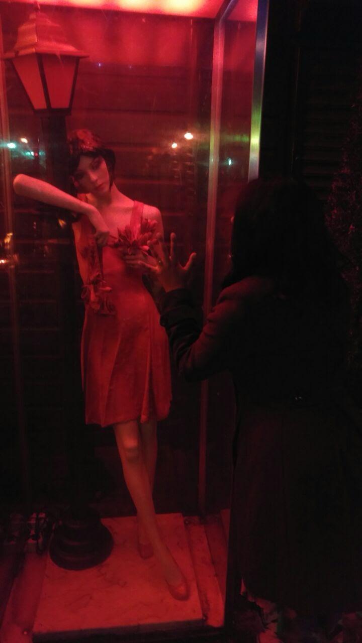 Photo of a statue representing a prostitute at the Red-Light District, in Amsterdam, the Netherlands. Foto de uma estátua representando uma prostituta no Distrito da Luz Vermelha, em Amsterdã, na Holanda.