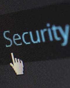 Foto de Pixabay: https://www.pexels.com/photo/security-logo-60504/Foto de uma mão digital apontando para a palavra "segurança" em azul, colocada em uma tela escura.