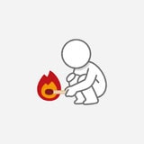 A minimalist icon showing a small person crouching on the ground, using a stick to tend a small fire. The figure is drawn in simple gray lines, while the flame is bright red, orange, and yellow. The image resembles a pictogram or symbol rather than a realistic drawing.